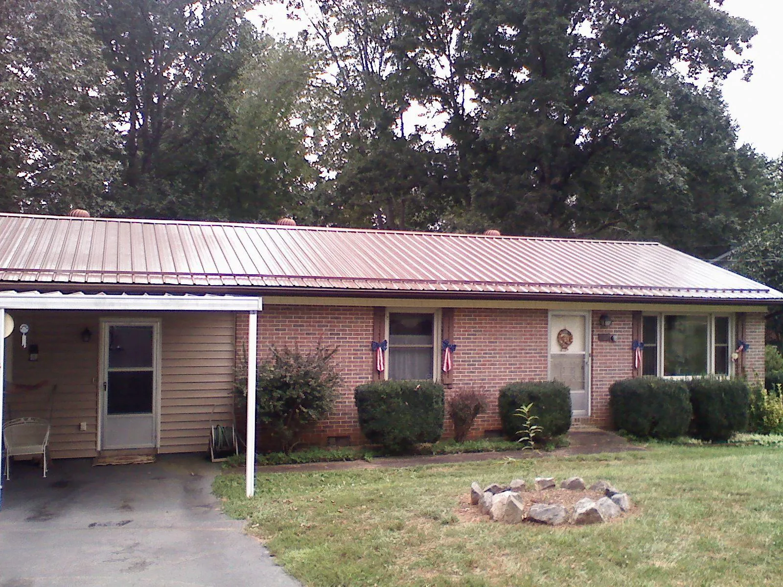 Bronze metal roof and carport on a brick ranch home — Roof Repair work by our crew in Dover